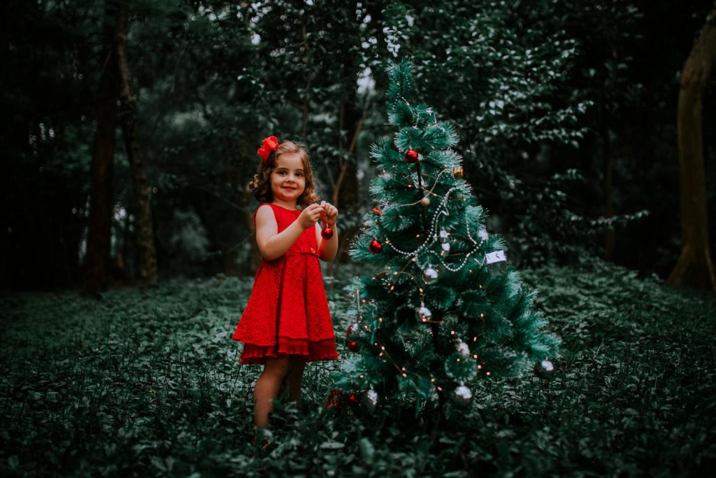 Girl Decorating a Christmas Tree with Christmas Balls