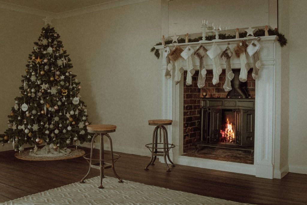 Christmas tree near two barstools at fireplace
